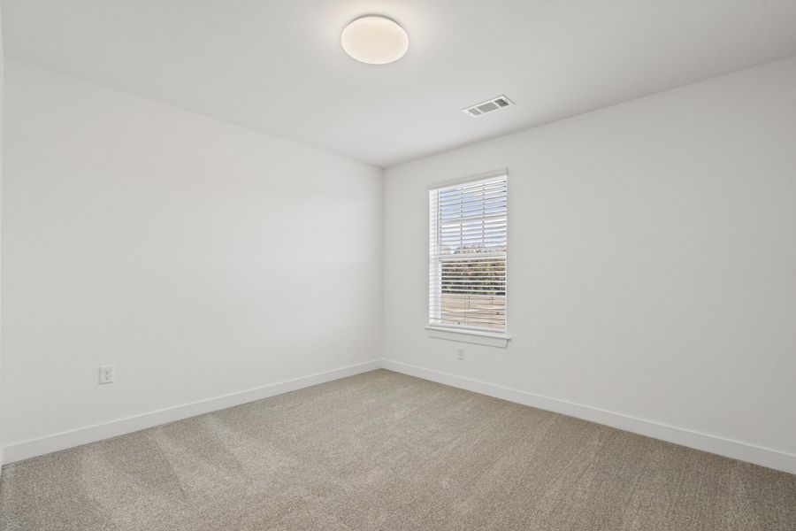 Spare room with light carpet and baseboards