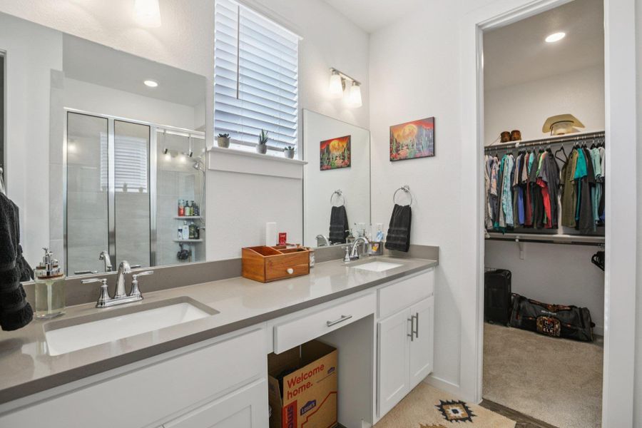 Bathroom with a spacious closet, double vanity, light colored carpet, a stall shower, and recessed lighting Bathroom with a spacious closet, double vanity, light colored carpet, a stall shower, and recessed lighting