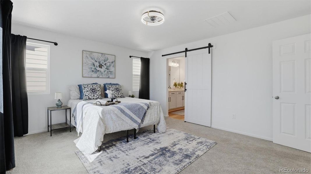 The upper level Primary Bedroom has a barn door into the spa-like Shower Bathroom.