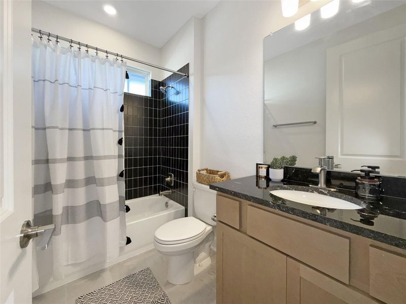 Bathroom featuring vanity, shower / tub combo with curtain, and light tile patterned flooring