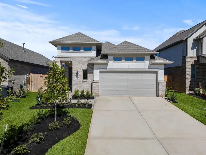 Front exterior of a new home in Grand Central Park, Conroe, TX, highlighting curb appeal (Image 1).