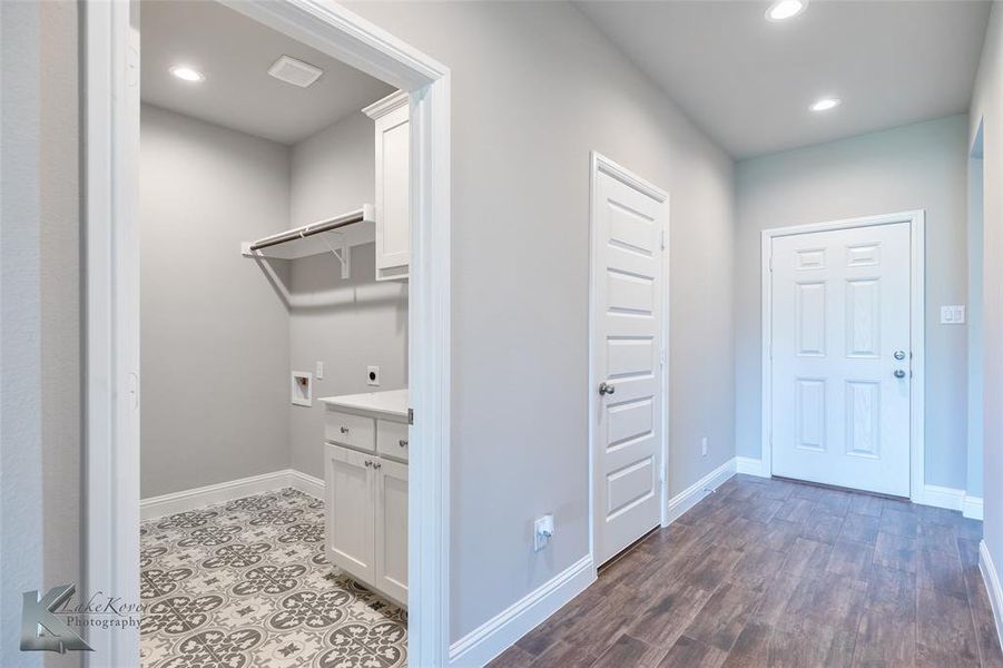 Entry way with ceramic tile and recessed lighting. Laundry room featuring recessed lighting, cabinet space, hookup for a washing machine and hookup for an electric dryer