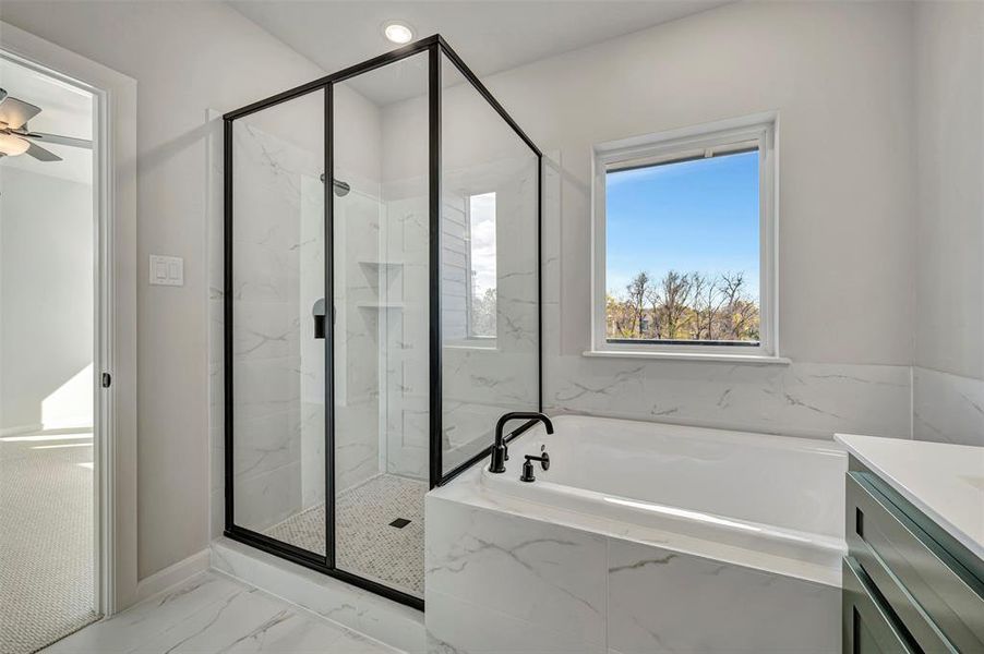 Full bathroom featuring light marble finish flooring, a marble finish shower, a garden tub, a ceiling fan, and vanity Full bathroom featuring light marble finish flooring, a marble finish shower, a garden tub, a ceiling fan, and vanity