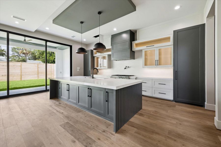 The kitchen features inset cabinetry and additional storage including pots and pan drawer, creating a clean, tailored look that blends seamlessly with the rest of the kitchen.