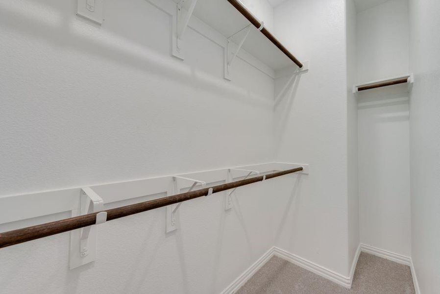 Walk in closet featuring light carpet Walk in closet featuring light carpet