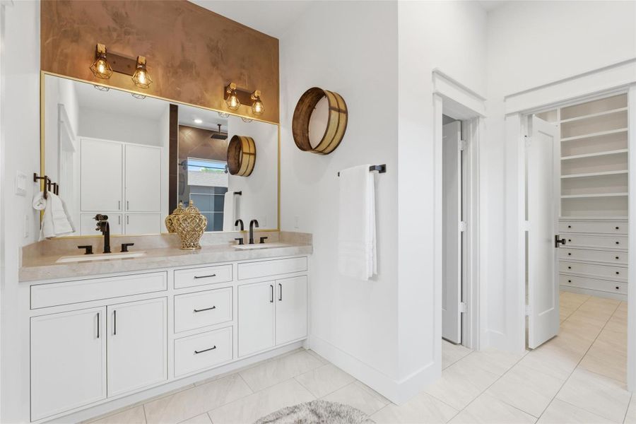 Dual sinks, a linen cabinet, private water closet, and a spacious walk-in shower complete this well-appointed four-piece bath.