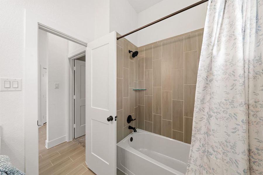 The combination tub/shower incorporates a full tile surround and adds a refined, well-appointed finish.