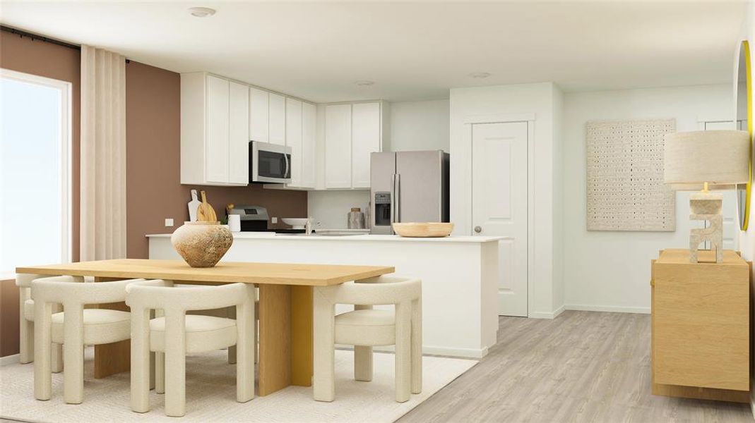 Kitchen with stainless steel appliances, light hardwood / wood-style floors, a kitchen breakfast bar, and white cabinetry