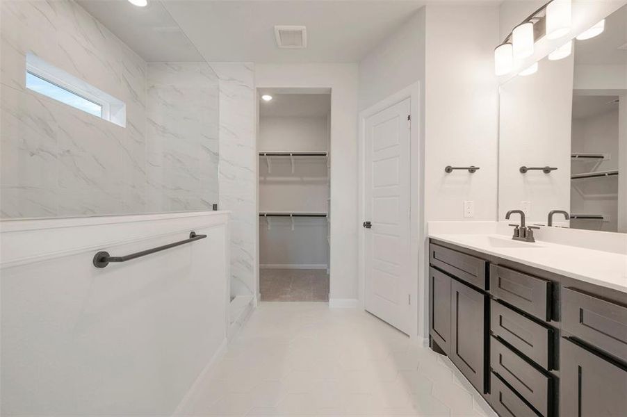 Bathroom vanity featuring a light-toned countertop, dark-finish cabinetry, and a contemporary faucet Bathroom vanity featuring a light-toned countertop, dark-finish cabinetry, and a contemporary faucet