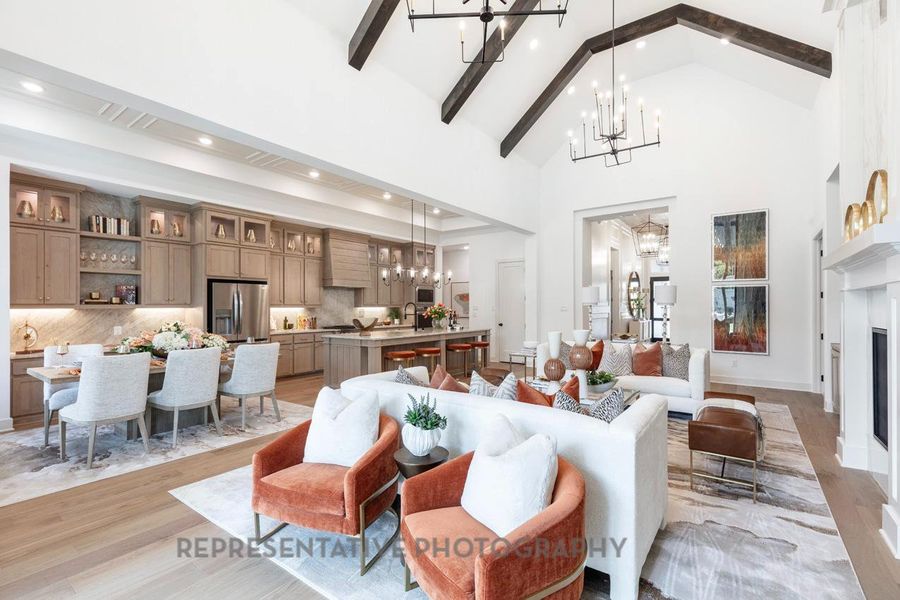Living area featuring a chandelier, beam ceiling, light wood-type flooring, high vaulted ceiling, and recessed lighting Living area featuring a chandelier, beam ceiling, light wood-type flooring, high vaulted ceiling, and recessed lighting