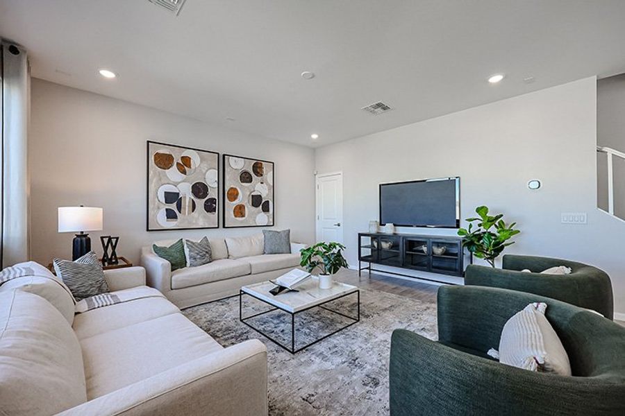 A living room with a tv and couches. A living room with a tv and couches.
