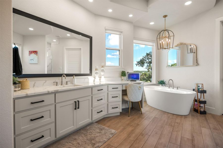 Bathroom with vanity, wood-type flooring, a tub, and a healthy amount of sunlight Bathroom with vanity, wood-type flooring, a tub, and a healthy amount of sunlight