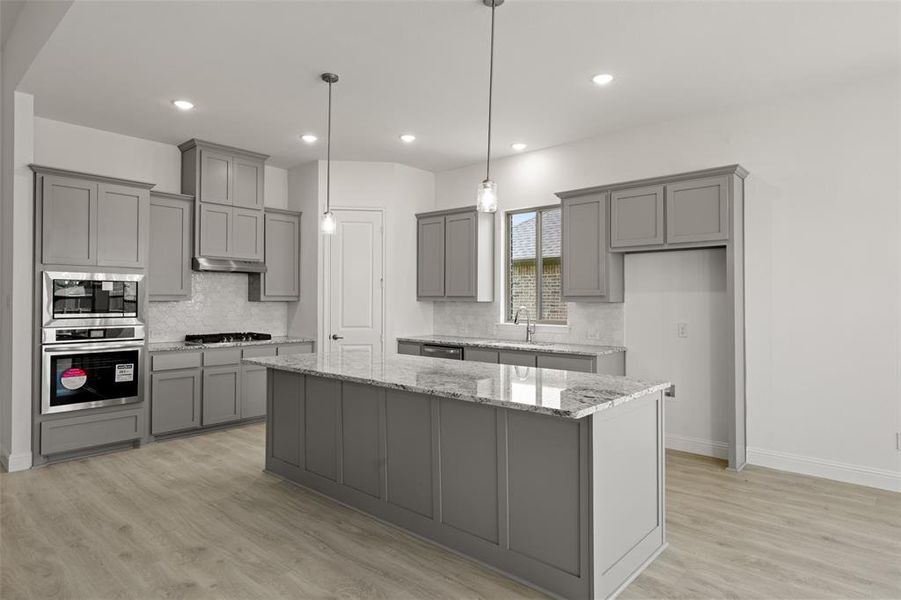 Kitchen featuring appliances with stainless steel finishes, gray cabinets, a center island, backsplash, and recessed lighting Kitchen featuring appliances with stainless steel finishes, gray cabinets, a center island, backsplash, and recessed lighting