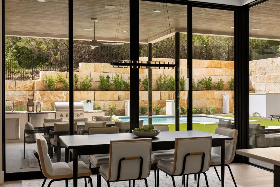 Framed by expansive glass and sophisticated finishes, the dining space offers an elegant setting for intimate dinners or formal hosting