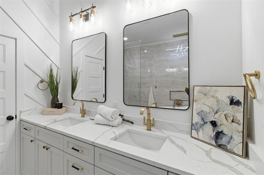 Dual vanity with undermount sinks, quartz countertops, and gold-finish fixtures