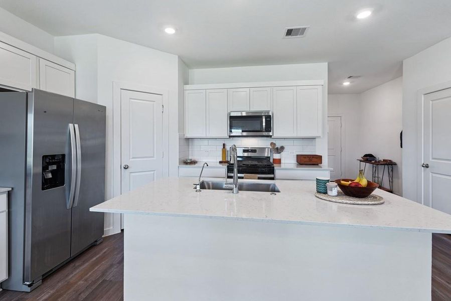 The large island with sink adds additional work space for cooking as well as additional seating opportunities!