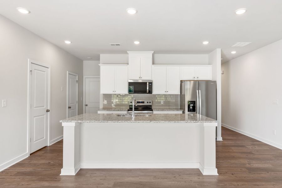 A kitchen with white cabinets.