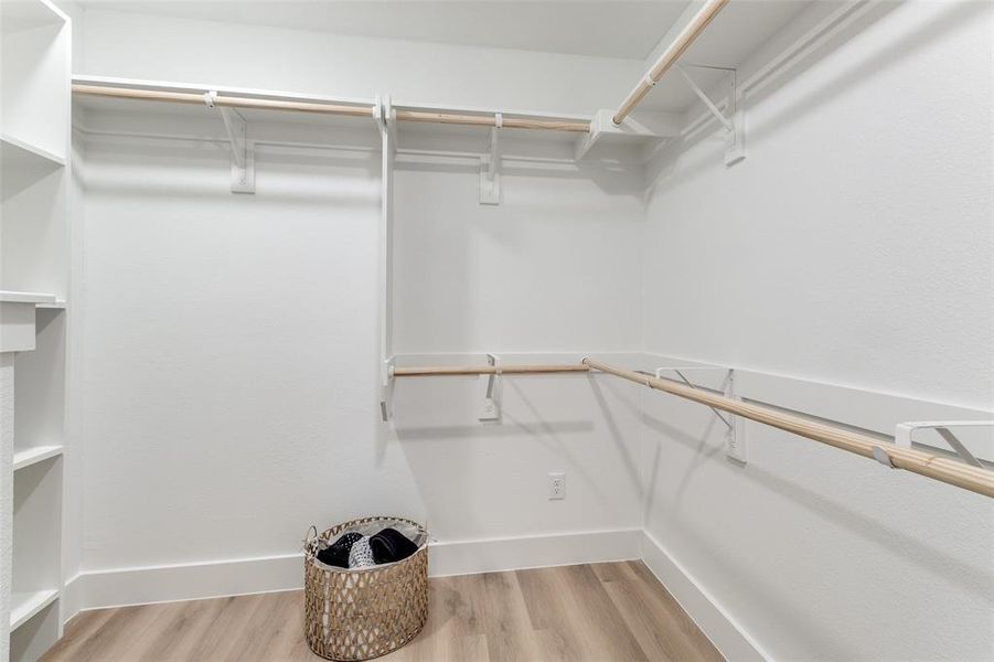 Spacious closet with light hardwood / wood-style floors