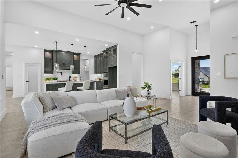 Open-concept living area featuring high ceilings, wood-finish flooring, and recessed lighting