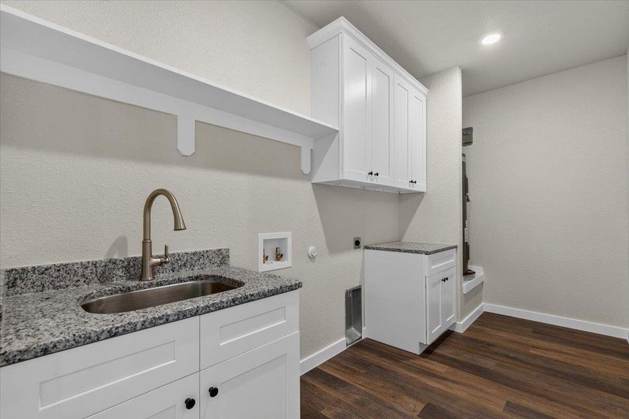 Gleaming granite countertops and dark wood flooring define this functional utility space. Gleaming granite countertops and dark wood flooring define this functional utility space.