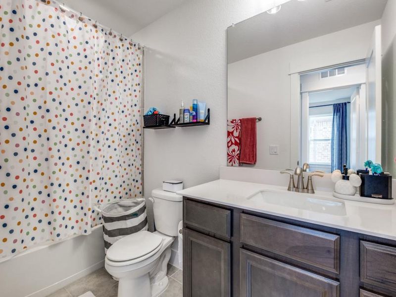Bathroom featuring vanity, tile patterned flooring, and shower / bath combination with curtain