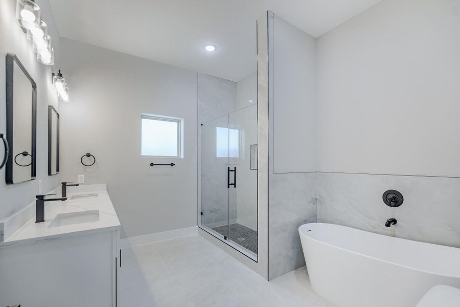 Primary bath with dual sinks, soaking tub, and walk-in shower