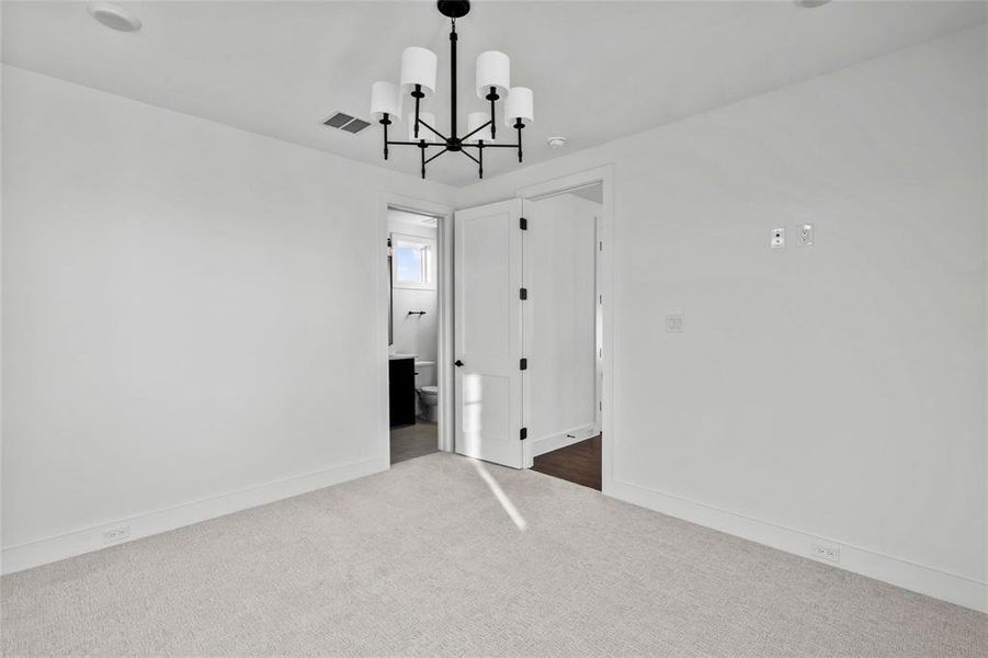 Empty room with carpet flooring and a chandelier Empty room with carpet flooring and a chandelier