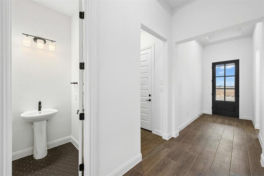 Entryway featuring wood-finish flooring and a black paneled door with glass inserts