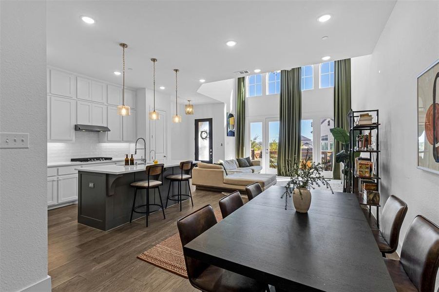 Dining room featuring a textured wall, recessed lighting, and dark wood finished floors