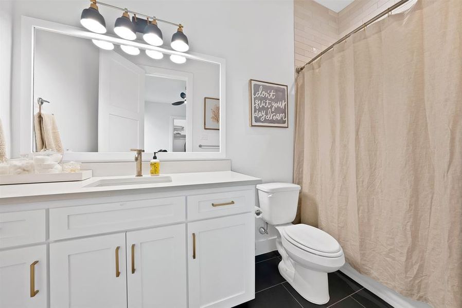 Bathroom featuring a white vanity with gold-tone hardware, a rectangular undermount sink, and a single-handle faucet Bathroom featuring a white vanity with gold-tone hardware, a rectangular undermount sink, and a single-handle faucet