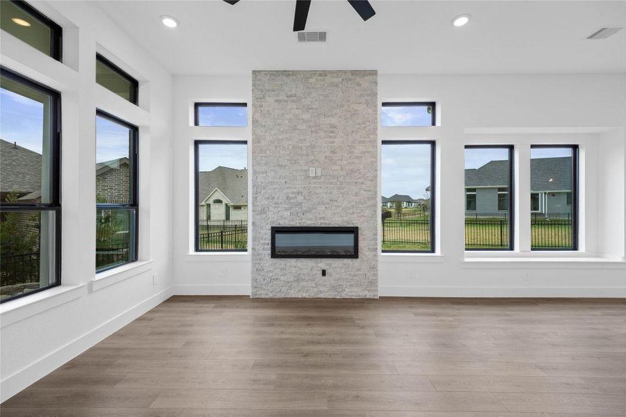This stunning, floor-to-ceiling electric fireplace serves as the room's central modern focal point blends with the home's contemporary aesthetic. The fireplace insert is designed to be flush with the wall, giving it a frameless, built-in appearance that enhances the sophisticated, clean lines.