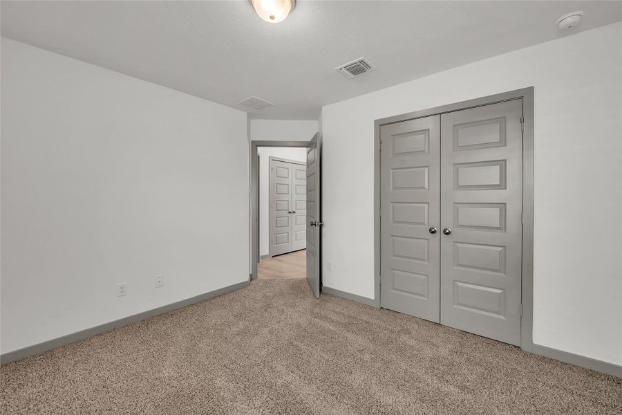 Unfurnished bedroom featuring a closet and light colored carpet