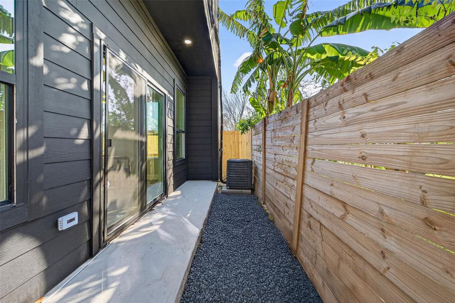 Private outdoor yard with sliding glass door access full wood privacy fencing—ideal for pets, morning coffee, or seamless indoor-outdoor living. Virtually staged. Representation of the landscaping.