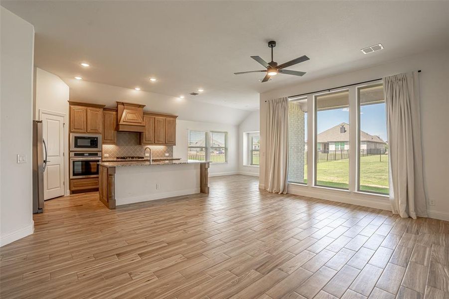 Open concept living, kitchen and dining located on the back of the house with large windows overlooking backyard. Open concept living, kitchen and dining located on the back of the house with large windows overlooking backyard.