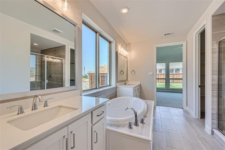 Bathroom with tile patterned flooring, separate shower and tub, and dual bowl vanity