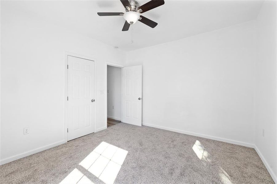 Unfurnished bedroom featuring carpet flooring and ceiling fan Unfurnished bedroom featuring carpet flooring and ceiling fan