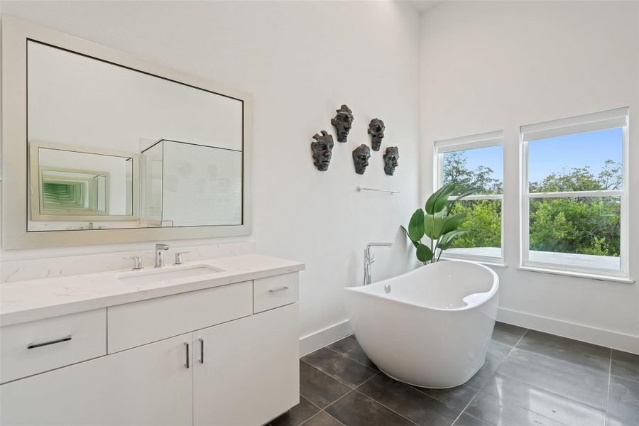 Bathroom featuring a freestanding bath, vanity, and tile patterned flooring