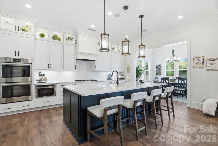 Large kitchen with custom cabinets and island with quartz countertops