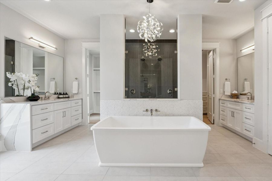 Primary suite includes separate vanities, his and her closets, and a "car-wash" shower!