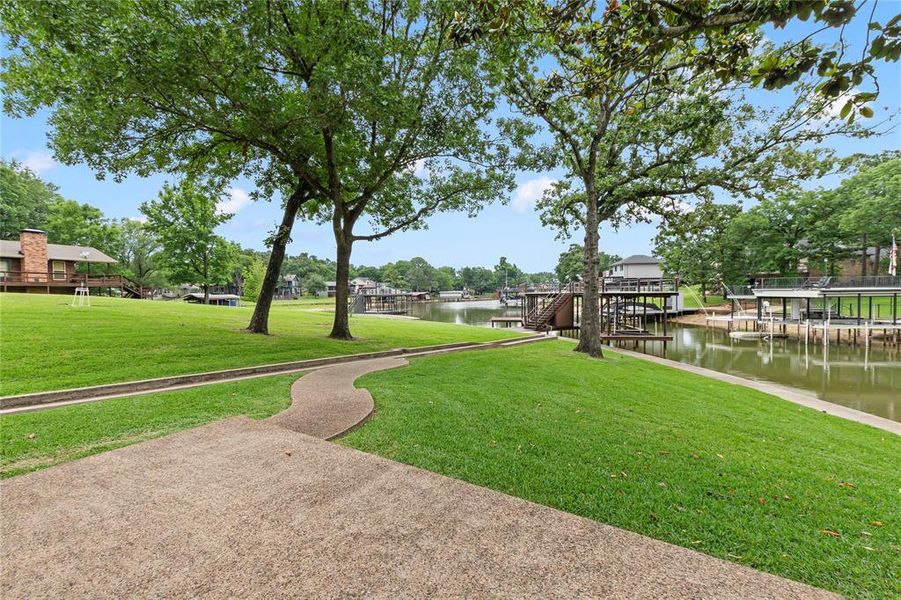 Lush, green backyard with plenty of open space, perfect for outdoor fun, relaxing afternoons, or entertaining, all overlooking your private lakefront and shimmering water views.