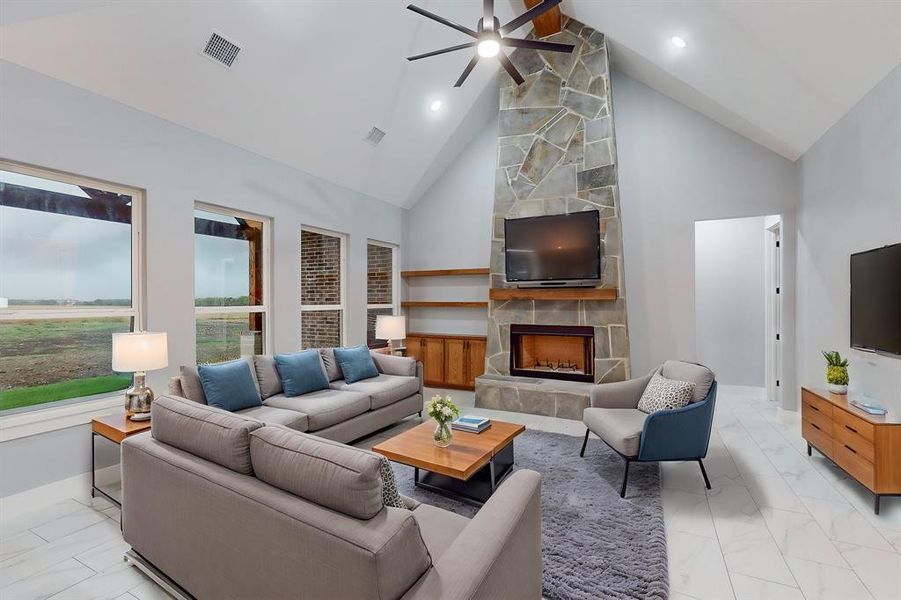 Living room featuring a stone fireplace, high vaulted ceiling, and ceiling fan