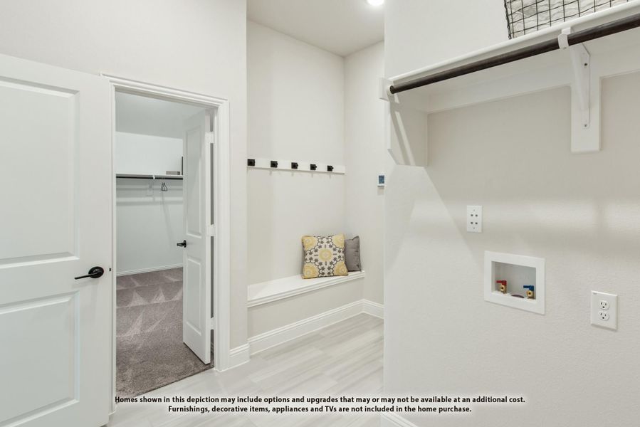 Mudroom with built-in bench, coat hooks, and shelving rod next to a walk-in closet doorway Mudroom with built-in bench, coat hooks, and shelving rod next to a walk-in closet doorway