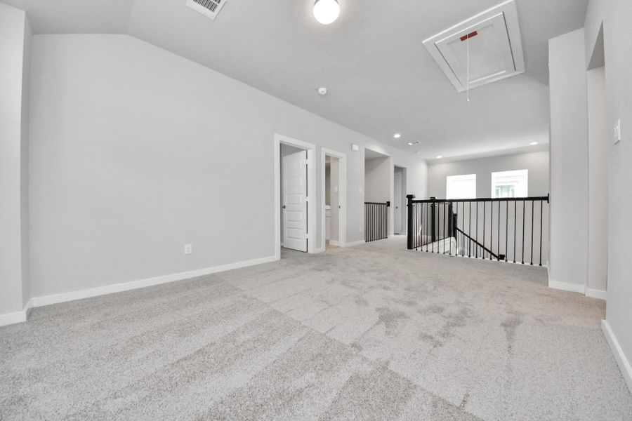 Come upstairs and enjoy a day of leisure in this fabulous game room! This is the perfect hangout spot or adult game room! Features plush carpet, high ceilings, custom paint and windows for plenty of natural light. Sample photo of completed home with similar floor plan. Actual colors and selections may vary.