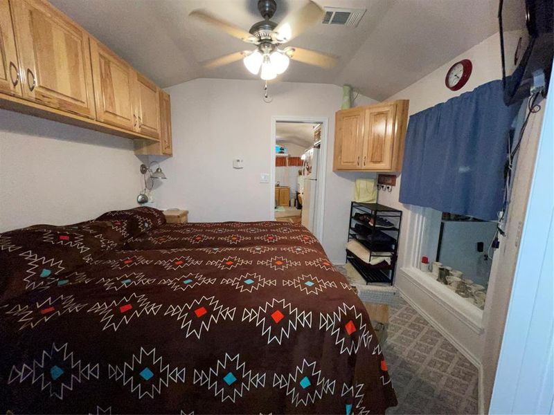 Carpeted bedroom featuring lofted ceiling and ceiling fan Carpeted bedroom featuring lofted ceiling and ceiling fan