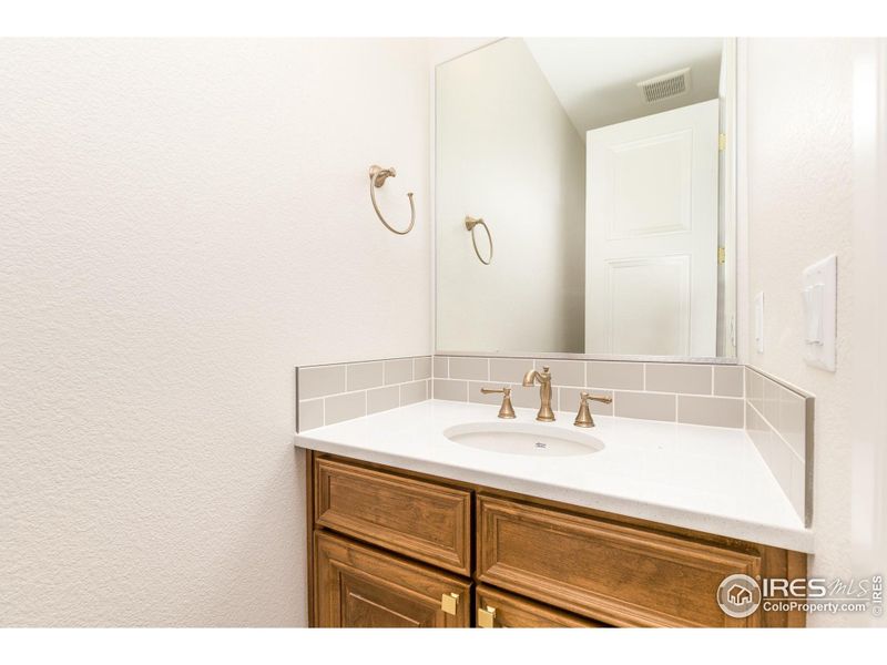 The main floor powder bath is in the center of the home near the laundry/mudroom and right off the great room