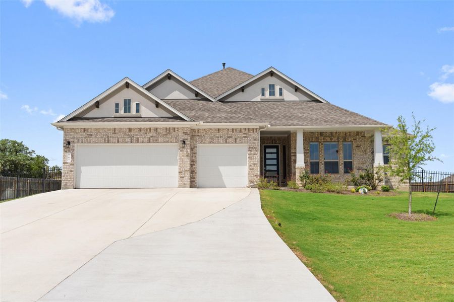 Craftsman-style house with roof with shingles, a garage, driveway, and brick siding