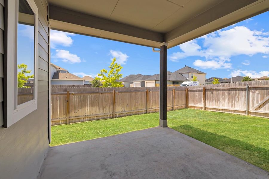 Fenced backyard with a patio area and a residential view Fenced backyard with a patio area and a residential view