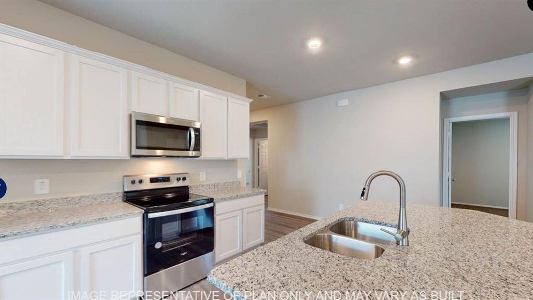 Modern kitchen featuring white cabinetry, stainless steel appliances, and light-colored countertops Modern kitchen featuring white cabinetry, stainless steel appliances, and light-colored countertops