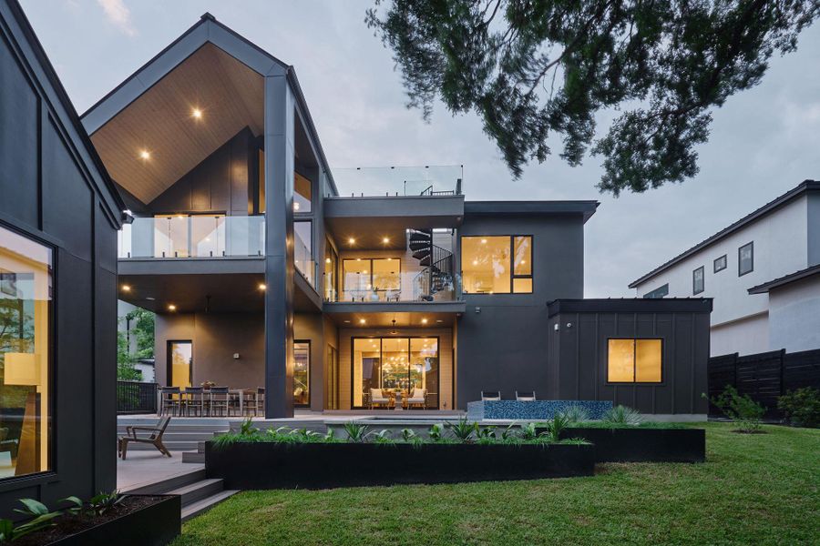 Back of property featuring board and batten siding, a balcony, and a patio Back of property featuring board and batten siding, a balcony, and a patio