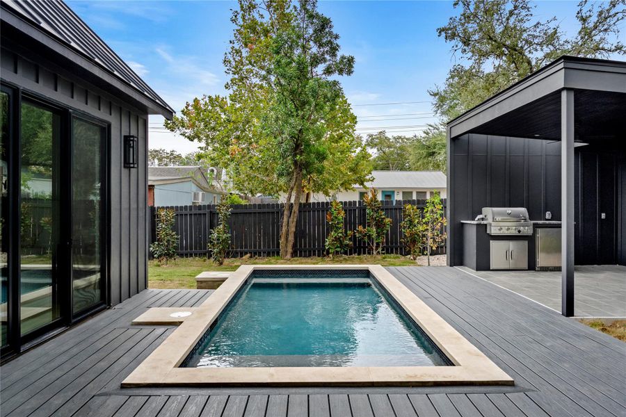 View of pool with a deck, area for grilling, and a patio